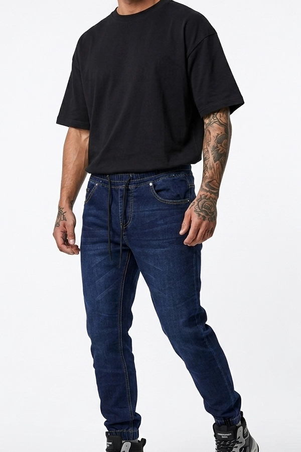 Άνδρας με σκούρο μπλε jogger jeans και μαύρο T-shirt