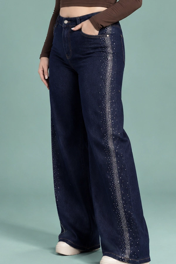 Woman wearing dark blue high waist wide leg jeans with rhinestone side embellishments and a fitted brown top.