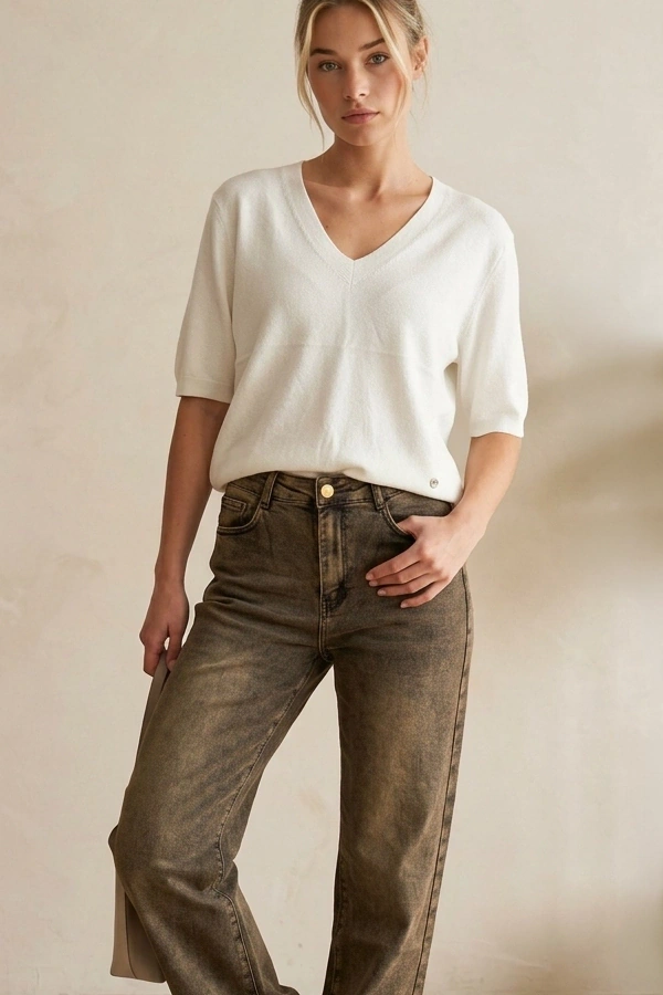 Woman wearing white cashmere-feel V-neck knit top with jeans