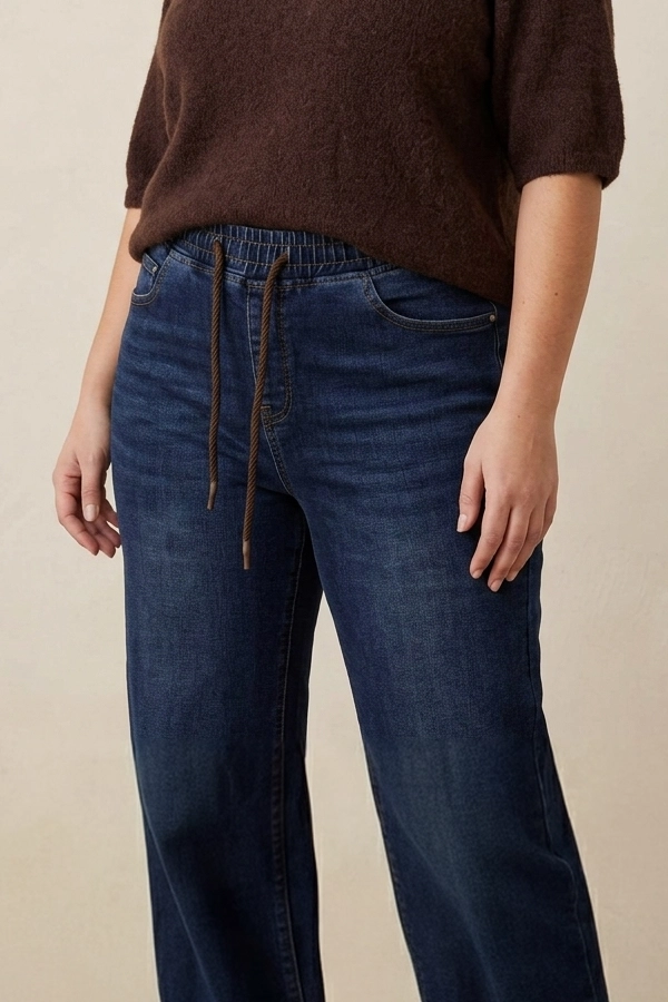 Plus size γυναίκα wearing wide leg high waist jeans σε dark denim