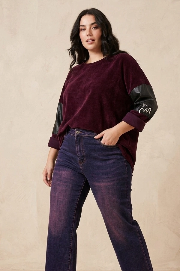 Plus size γυναίκα με μπορντό oversized κοτλέ μπλούζα και jeans