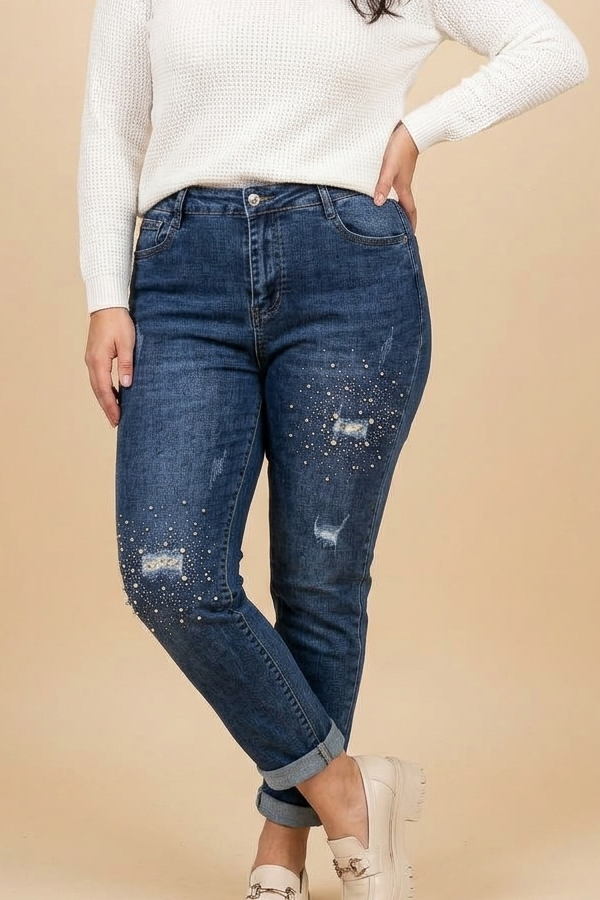 Plus size model wearing blue mom fit jeans with pearl and rhinestone embellishments